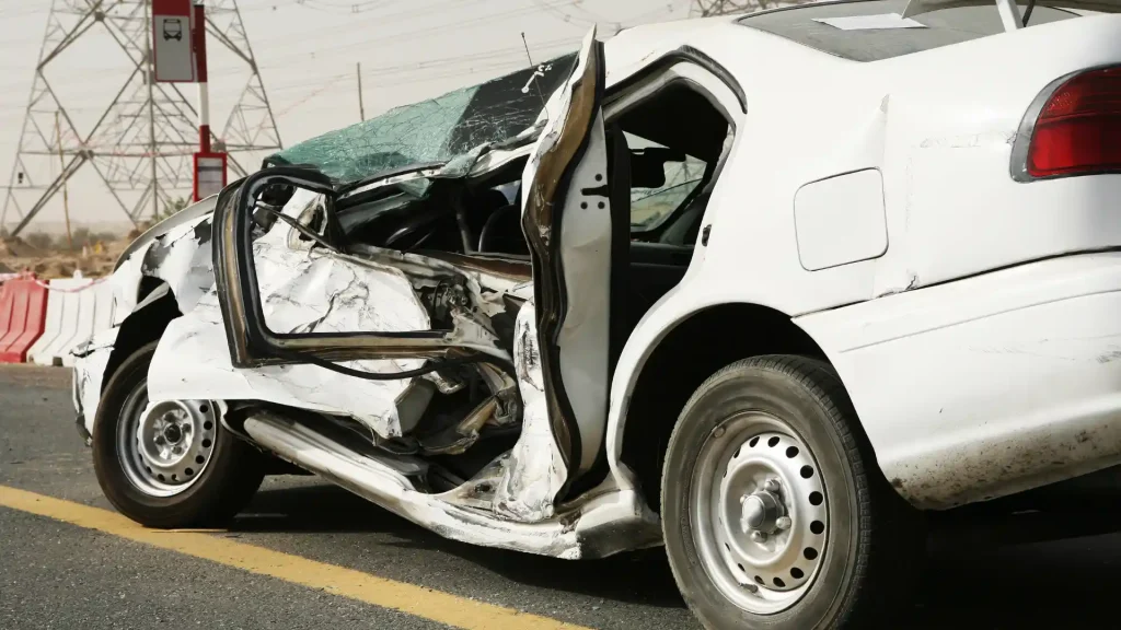 Severely damaged car with an open door after an accident.